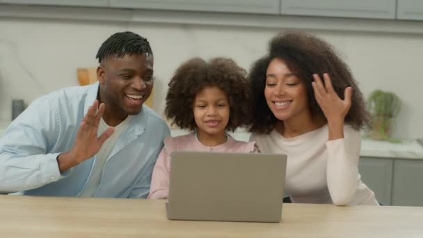 アフリカ系アメリカ人の幸せな両親 遠隔コミュニケーションPcキッチンビデオ通話ラップトップファミリー振るこんにちは娘ガールと父親の母親 家庭でオンラインコンピュータ会議 — ストック動画