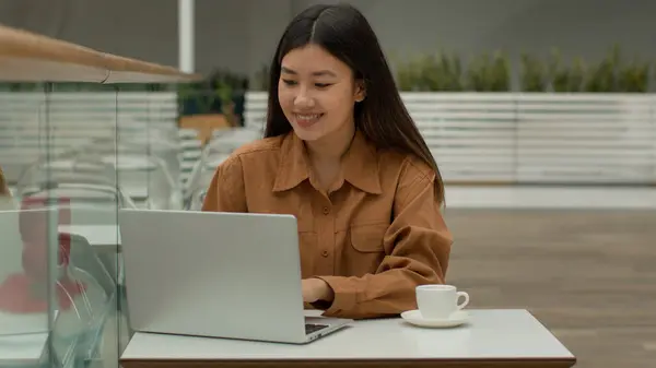 アジアの美少女中国のビジネス女性は ラップトップドリンクコーヒー韓国人ビジネスマンフリーランサーの学生がコンピュータチャットにタイピングし カフェのワークスペースでカジュアルなワーキングユースWi Fiを使用して働きます — ストック写真