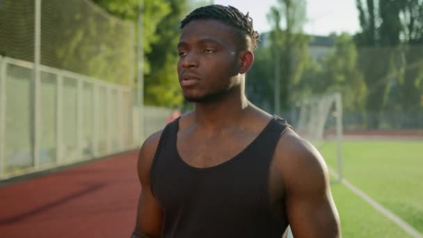 アフリカ系アメリカ人ヒップスターマンスポーツマンランナーは アウトドアのトレーニングのためのスマートウォッチでヘッドフォンリスニングミュージックプレイリストを着用 男性スポーツ選手ペンシブ筋肉運動スポーツ健康的なライフスタイル — ストック動画