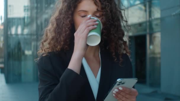 クローズアップ女性 コーヒーを飲んで歩く コーヒー コーヒー ビジネスマン ビジネス 通りの都市 携帯電話のニュース 混乱した メッセージ — ストック動画