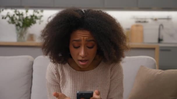 Afro Amerikaanse Jonge Vrouw Leest Slecht Nieuws Mobiele Telefoon Thuis — Stockvideo