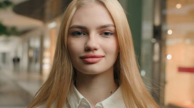 İş kadını, Kafkasyalı, 20 'li yaşlarda kadın, giyim mağazası, giyim mağazası, moda mağazası, şirket CEO' su alışveriş merkezindeki kameraya bakıyor. Kafasına yakın çekim başarılı bayan.