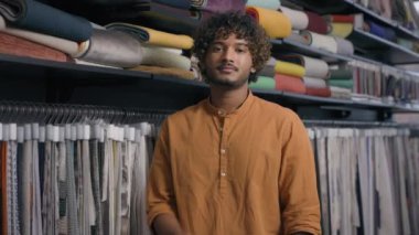 Mutlu gülümseyen Arap adam kumaş atölyesindeki alıcıdan doku numuneleriyle tekstil kumaş ipeği kumaş kumaş kumaş kumaş kumaş kumaş malzemesi, kumaş mağazasında kesişen etnik adam.