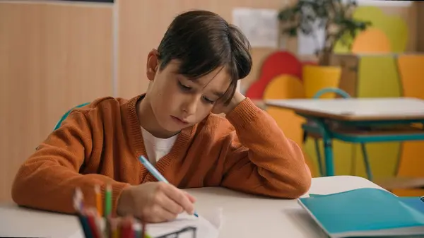 Little school boy primary schoolboy Caucasian son kid child clever smart writing task exercise at class lesson tired failure problem irritated trouble education difficulty hard studying learning study