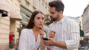 Kafkas erkek kadın cep telefonu kullanıyor akıllı telefon internet haritaları konum turizmi turizm gezi gezisi GPS navigasyon uygulaması şehir merkezi cadde dışındaki şaşkın erkek eğlence merkezi şehir yolu