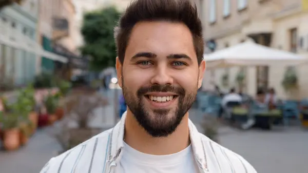 Close up handsome Caucasian European man tourist traveler smiling laughing on city street portrait guy model dental toothy smile happy joyful male enjoy lifestyle weekend looking at camera outdoors