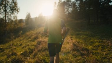 Geriye bakış sporu tanınamaz bin yıllık beyaz erkek adam iz sürme koşucusu koşucu koşucu koşu rotası antrenmanı triatlon güneş ışığı güneş ışığı dağ doğumu doğa ormanı