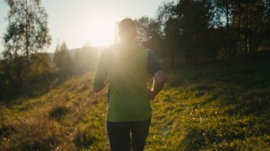 Geriye bakış sporu tanınamaz bin yıllık beyaz erkek adam iz sürme koşucusu koşucu koşucu koşu rotası antrenmanı triatlon güneş ışığı güneş ışığı dağ doğumu doğa ormanı