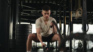 Kaslı, güçlü, beyaz, erkek, vücut geliştirme antrenörü, sporcu, erkek sporcu, savaş halatları, kol kasları, spor salonunda fiziksel egzersiz.