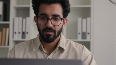 Arap Hindistanlı işadamı bilgisayarla uğraşmaktan yorulmuş hasta iş adamı kaşıntılı gözlerini ovuşturuyor gözlükleri çıkarıyor kötü görüş, baş ağrısı, migren, sağlık problemi.