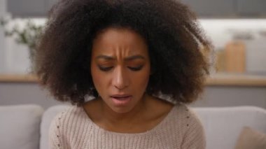 Endişeli Afro-Amerikan etnik kadın elinde cep telefonuyla koltukta kötü haber alıyor. Gergin, şaşkın, bayan, bayan, sorunlu, akıllı telefon kazası.