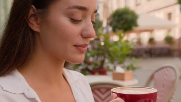 美しい成功したヨーロッパの少女を閉じる コーヒーブレイクの美味しいカップを飲みます 芳香族の喜び コーカサス ビジネス女性の街 アウトドア休憩 リラクゼーション ポジティブ カフェ 熱いおいしい — ストック動画