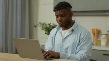 Afrikalı etnik adam serbest çalışan erkek, çift ırklı erkek işadamı, ev sahibi, bilgisayarlı ev sahibi, uzak mesafelere çalışıyor, bilgisayar alışverişi yapan internet mutfaklarında sohbet ediyor.