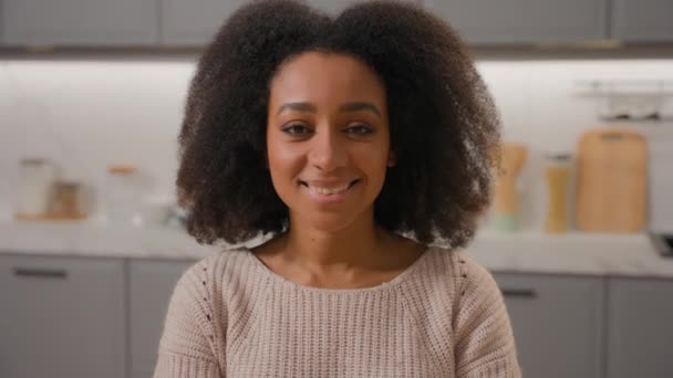 非洲裔美国女人漂亮的年轻姑娘积极快乐的女士近视面带微笑看着相机女房东的头拍着幸福的房主在家里厨房开开开心心的笑着 — 图库视频影像