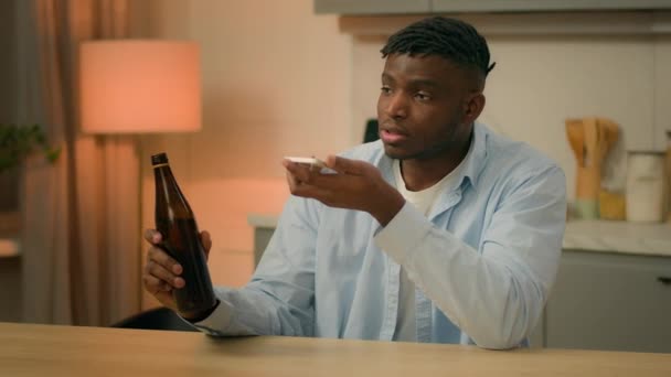 酔っぱらったアルコール中毒 アフリカ系アメリカ人男性 アルコール ビール キッチン 携帯電話 スピーカー ボイスメール 携帯電話 — ストック動画