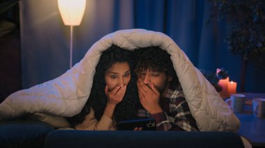 Birkaç Hintli adam ve Arap kadın gece yatakta battaniyenin altında çıkıyorlar. Aile sevgilisi korku filmi izlerken şok oldu.