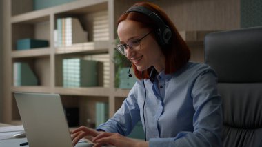 Beyaz tenli, gülümseyen iş kadını iş görüşmesi konferansı. Ofis kızı, kulaklık takıyor. Video çağrı merkezi operatörü.