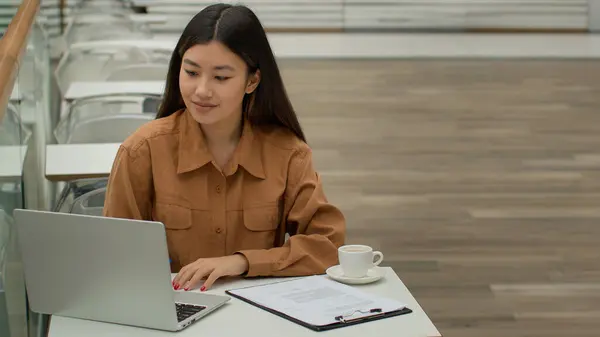 アジアの女性マルチタスクビジネス女性起業家民族中国の女の子の学生は カフェでオンラインで勉強多人種のオフィスマネージャーは ノートパソコンを入力して書類を書く保険書類を書きます — ストック写真