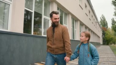 Baba ve kızı sokakta yürüyorlar sohbet ediyorlar mutlu bir aile birlikte mutlu bir liseli kız öğrenci okul dersleri çocuk ailesi sevgi dolu bir desteğin keyfini çıkarıyorlar.
