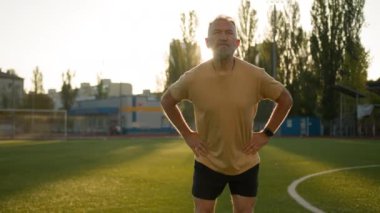 Spor antrenmanı yapan beyaz bir adam sabah stadyumunun dışında spor yapıyor. Sağlıklı yaşam tarzı, sporcuyu motive ediyor. Fiziksel aktivite, esnek dinlenme hareketleri, jimnastik sporu.