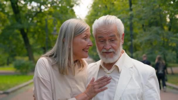 退休快乐微笑白种人老年夫妇家庭男人女人祖母外婆婆家谈笑风生散步公园外新鲜空气保健关系退休 — 图库视频影像