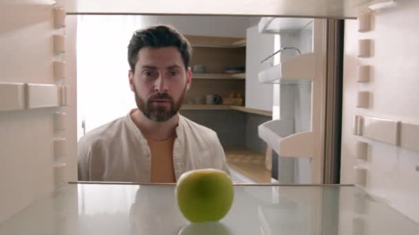 内側からの視点 冷蔵庫 Pov 空の冷蔵庫のコーカサス大人の男性 悲しみの内側を見る つだけのリンゴが必要な食品配達の店のプロダクト 宅配便 家で不満の振動頭部 — ストック動画