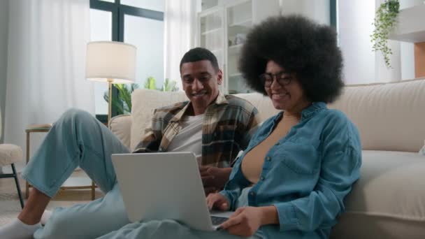남편과 아프리카계 미국인 배우자 노트북 컴퓨터를 온라인 쇼핑을 즐기는 여자에서 — 비디오