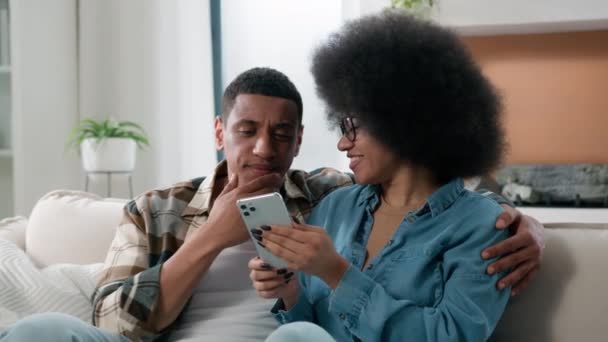 アフリカ系アメリカ人の配偶者 カップル ガール ソファー ショッピング オンライン 携帯電話 スマートフォン ストア — ストック動画
