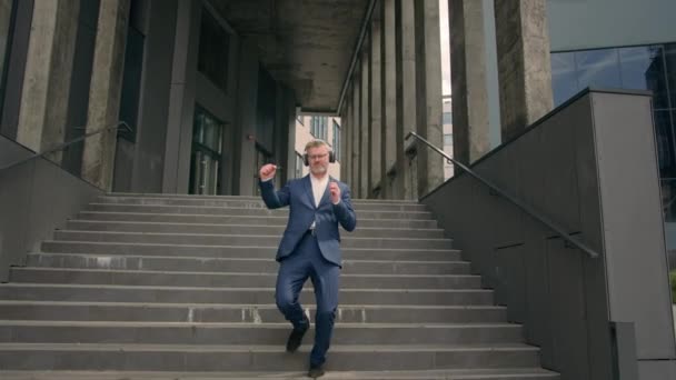 Счастливый Пожилой Человек Наушниках Телефоном Mp3 Музыкальное Приложение Спускается Лестнице — стоковое видео