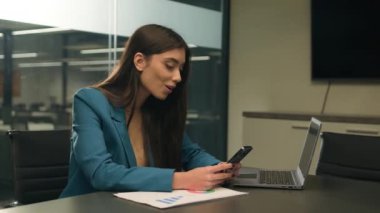 Kafkasyalı iş kadını ofis çalışanı cep telefonu tebligatında iyi haberler okuyor. Şaşılacak komik mesajlar. Akıllı telefonlar.