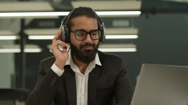 印度商人放松阿拉伯男性商人办公室创业者喜欢用无线现代耳机耳机听音乐在工作场所听音频歌曲音乐暂停 — 图库视频影像