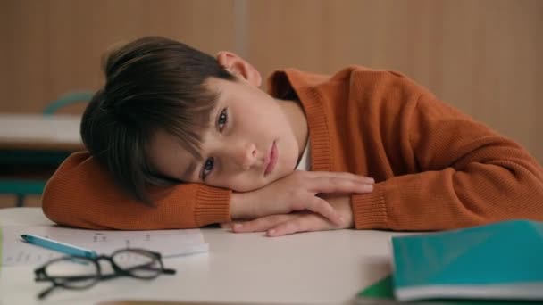 コーカサスは 学校の小学校教育学習で退屈したボーイの睡眠 疲れた悲しい動揺 テーブルデスクのレッスンクラスで横たわる子供の少年少年生徒 健康問題を緩和する — ストック動画