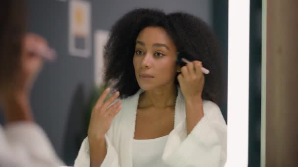 女性の鏡の反射美の訪問の構造のコンセプト魅力的でアフリカ系アメリカ人の女性の女性は家で顔のスキンケアの調子のマットを準備する化粧品のための粉を加えます — ストック動画