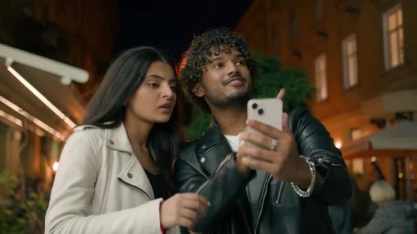 インドのアラビアのカップル旅行はナビゲーターに問題があります 電話マップ オンライン検索場所 夜の都市で失われた指摘する方向 男性旅行ナビゲーションGpsアプリ — ストック動画