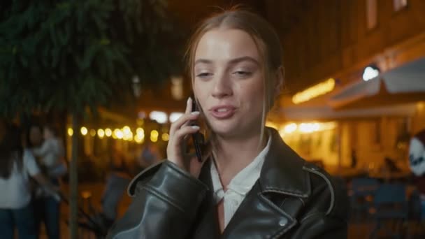 ヨーロッパの若い女性 ゴシップ 携帯電話 スマートフォン 夜の都市外 話し合う 女の子 モデル ガールフレンド ストリート — ストック動画