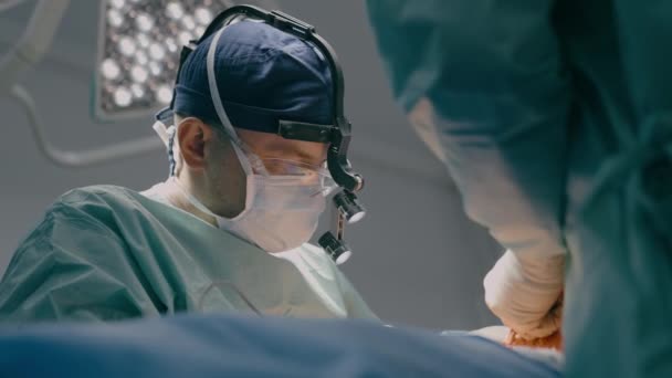贴身外科医生戴防护面罩医生医疗队操作病人腹腔镜手术显微镜手术医疗工具在手术室医院诊所的医疗护理 — 图库视频影像