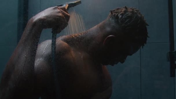 아프리카계 미국인 남자가 샤워를 어두운 욕실에서 헹구는 피곤한 뜨거운 떨어지는 — 비디오
