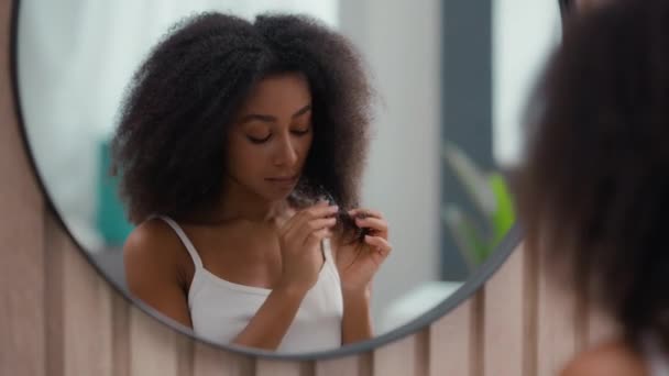 心配した美しい悲しい動揺 アフリカ系アメリカ人女性女性 鏡の反射を見ている女性 脆弱な曲がりくねった髪の損傷ドライカール不健康な分割エンドホルモン問題ビタミン欠乏 — ストック動画