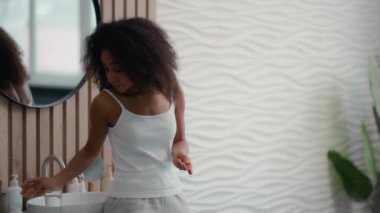 Sağlıklı afro-amerikan güzel kadın hasta kız bir bardak suyla hap içiyor ilaç vitamin takviyeleri içiyor sabah banyoda güzellik ilacı cilt kılı bakımı için