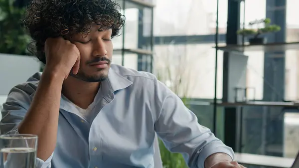 Tired exhausted bored Indian Arabian man business employer manager yawn need sleep fatigued lack energy sleeping overworked overload laptop work in office boring job burnout drowsy businessman yawning