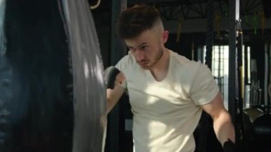 Kendini adamış sporcu boksör boksör boks torbası modern fitness spor salonunda beyaz erkek boksör boksör boks şampiyonu antrenmanı profesyonel boks kutusunu patlattı. Aktif kas sporcusu güçlü motivasyon egzersizi