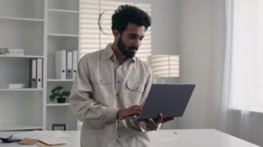 Arap Hindistanlı Müslüman etnik adam mutlu, güler yüzlü, erkek işadamı milenyum serbest, yönetici, işveren, ofis bilgisayarlarında bilgisayar işi projesi üzerinde çalışan iş adamı.