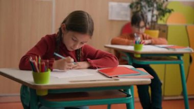Kafkasyalı küçük liseli kız, okul dersi yazıyor. Cevap ver. Soru sor, zeki çocuk cevap ver.