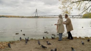 Beyaz, orta yaşlı, olgun bir çift. Sonbahar parkında gölde ördek besleyen bir adam. Hafta sonu emekli kadın.