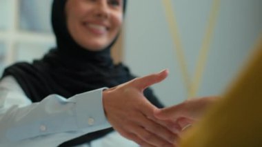 Mutlu Müslüman iş kadını tesettürlü el sıkışırken ofis satış elemanı ile el sıkışırken müşteri el sıkışırken başarılı iş birliği anlaşmasını tebrik ederim kadın ortaklığı.
