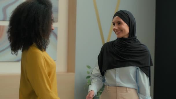 ビジネスパートナーは オフィスのヒジャブパートナーシップ契約でアフリカ系アメリカ人の少女ハンドシェイクアラビアのイスラム教徒女性を握る幸せな陽気なビジネスウーマンハンドシェイク — ストック動画