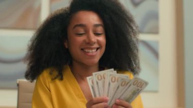 Mutlu Afrikalı Amerikalı etnik iş kadını banka çalışanı finans muhasebecisi ofis yerinde dolar sayıyor neşeli iş kadını para maaşı bütçesi gülümsemesi sayıyor