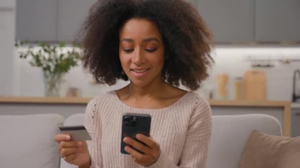 非洲裔美国妇女使用手机 女客户在网上订购单 在家支付金钱 成功地在线购物 用信用卡和智能手机开心地微笑 — 图库视频影像