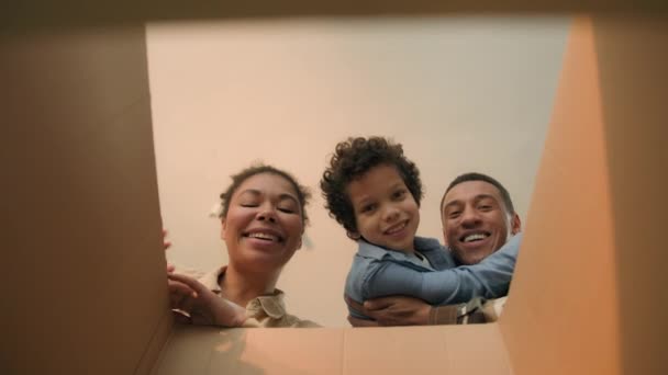箱の中のPovビュー幸せな家族アフリカ系アメリカ人の笑顔のお父さん小さな息子の男の子は パッケージの配達をチェック オンラインショッピング注文 近い段ボール小包移動日帰宅 — ストック動画