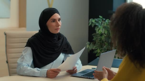 ヒジャブHrマネージャービジネス雇用主のアラビアのイスラム系ビジネスマンは 顧客アフリカ系アメリカ人女性失業者へのクレジットを拒否する書類を拒否します ネガティブな結果 オフィスで拒否されません — ストック動画
